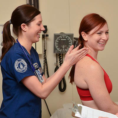 A student nurse practicing an assessment with another student.
